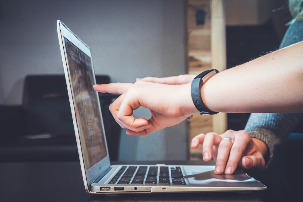 Dua orang meninjau informasi pada layar laptop bersama